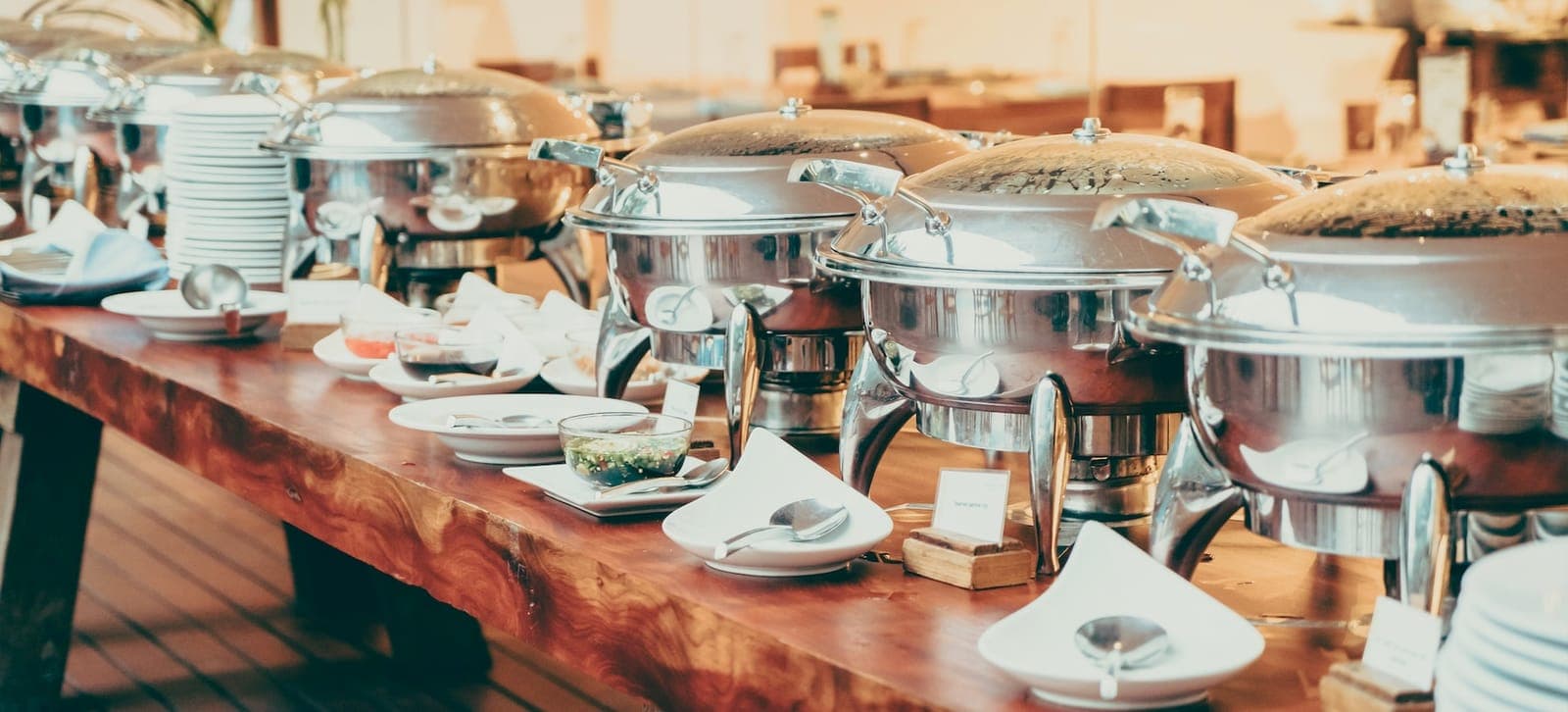 Rows of chafing dishes along a buffet table
