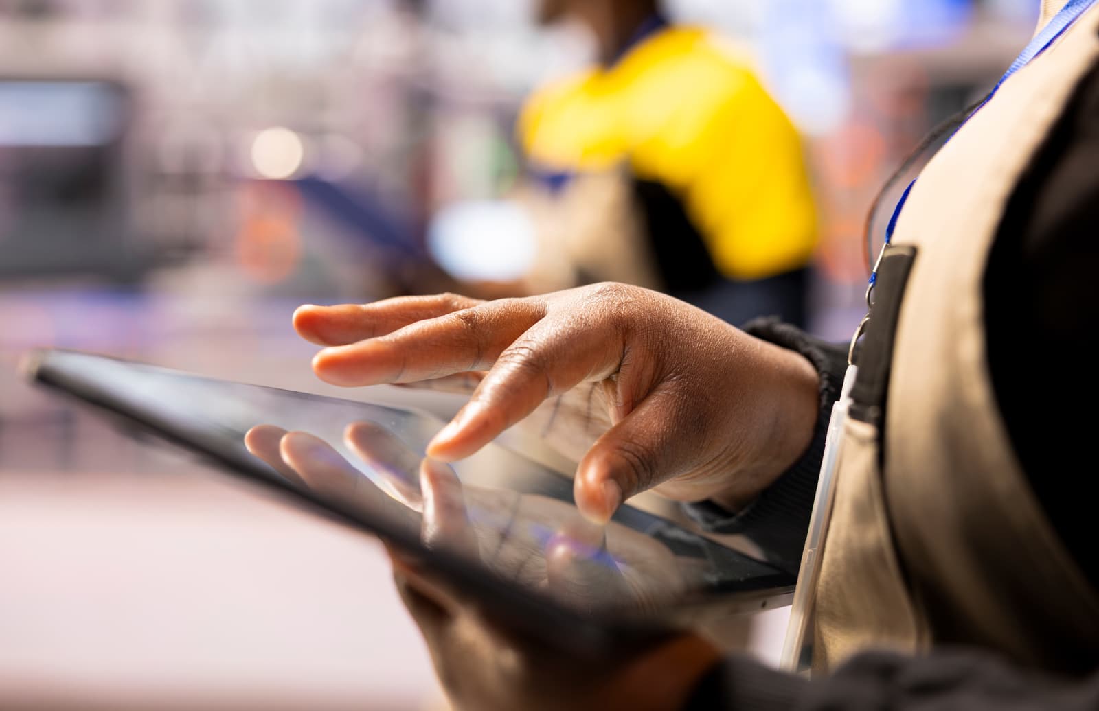 Engineer using a tablet on a busy operations floor